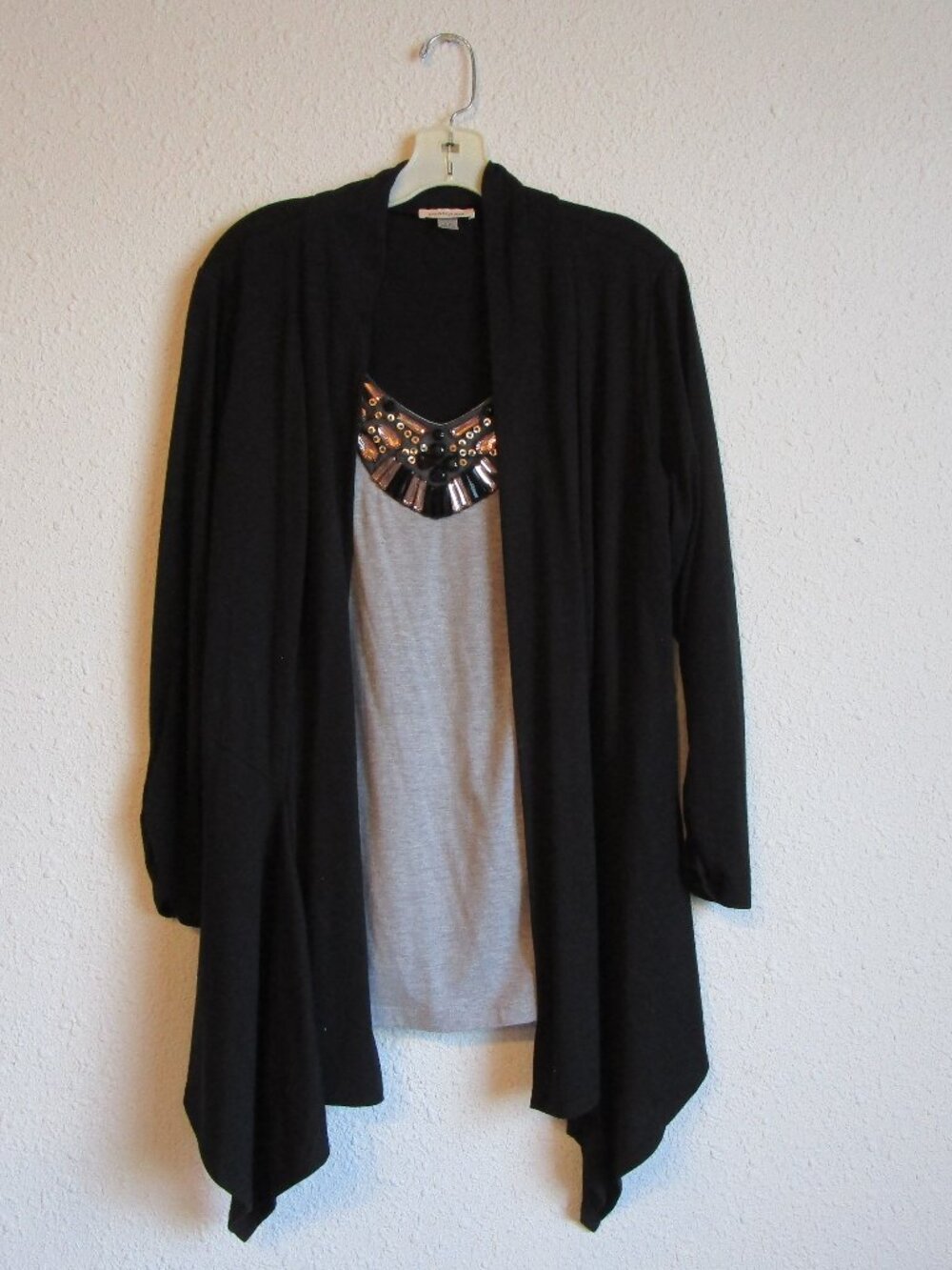Poly-rayon blend sweater top with rhinestone embellishmnet on chest.